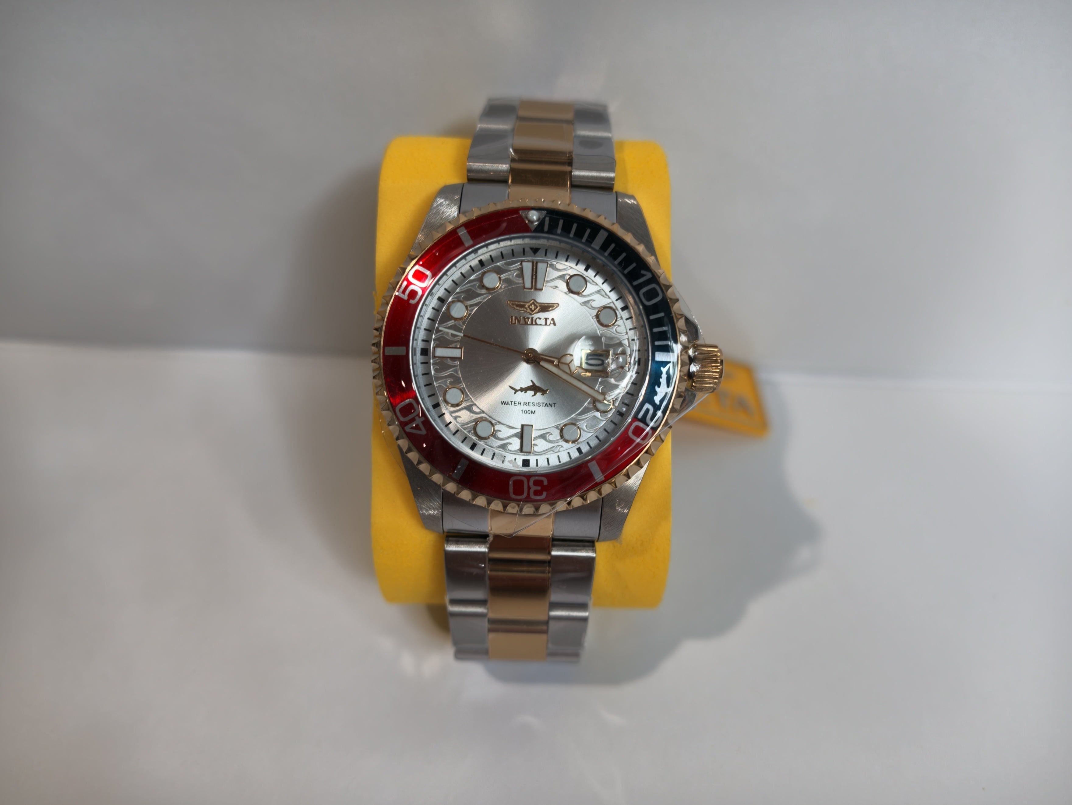 	Invicta Pro Diver two-tone watch with red and blue bezel on display stand
