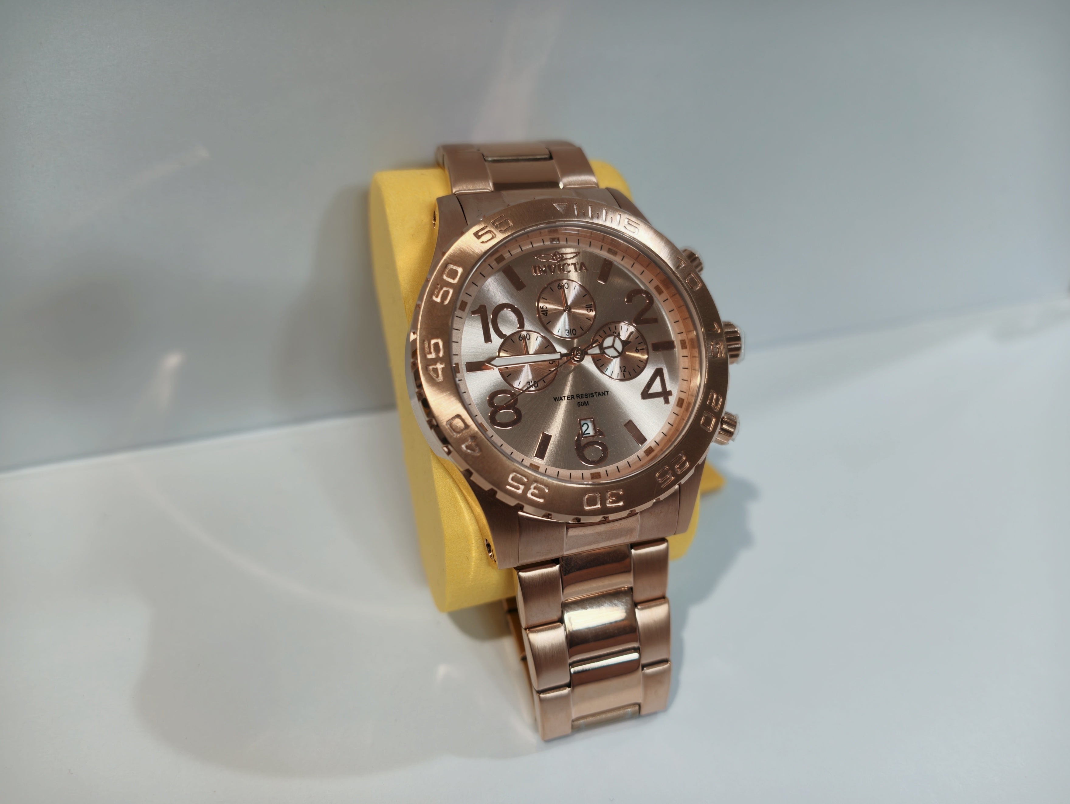 Invicta rose gold watch face detail with tachymeter bezel and crown