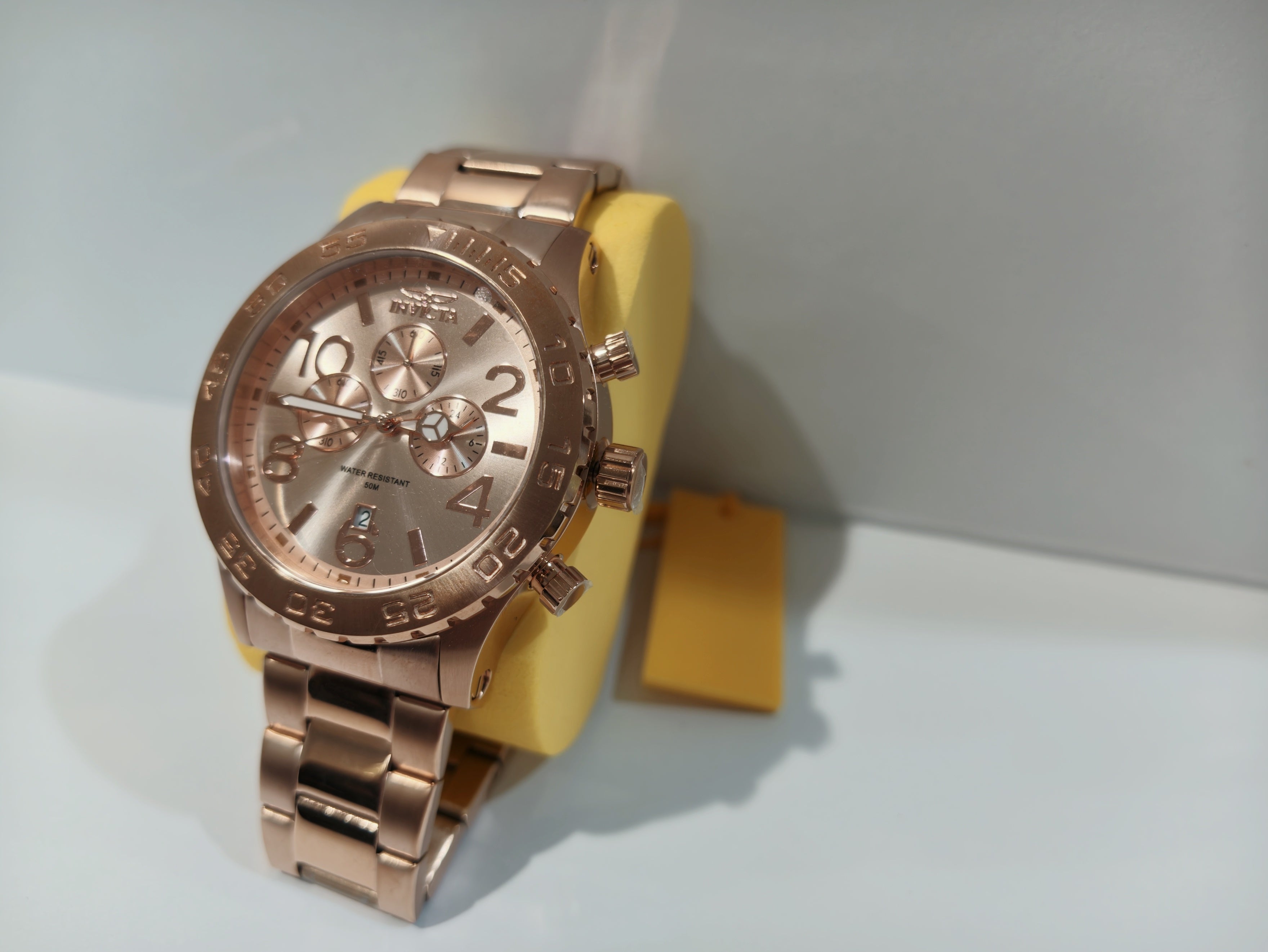 Invicta rose gold chronograph watch angled view on display stand