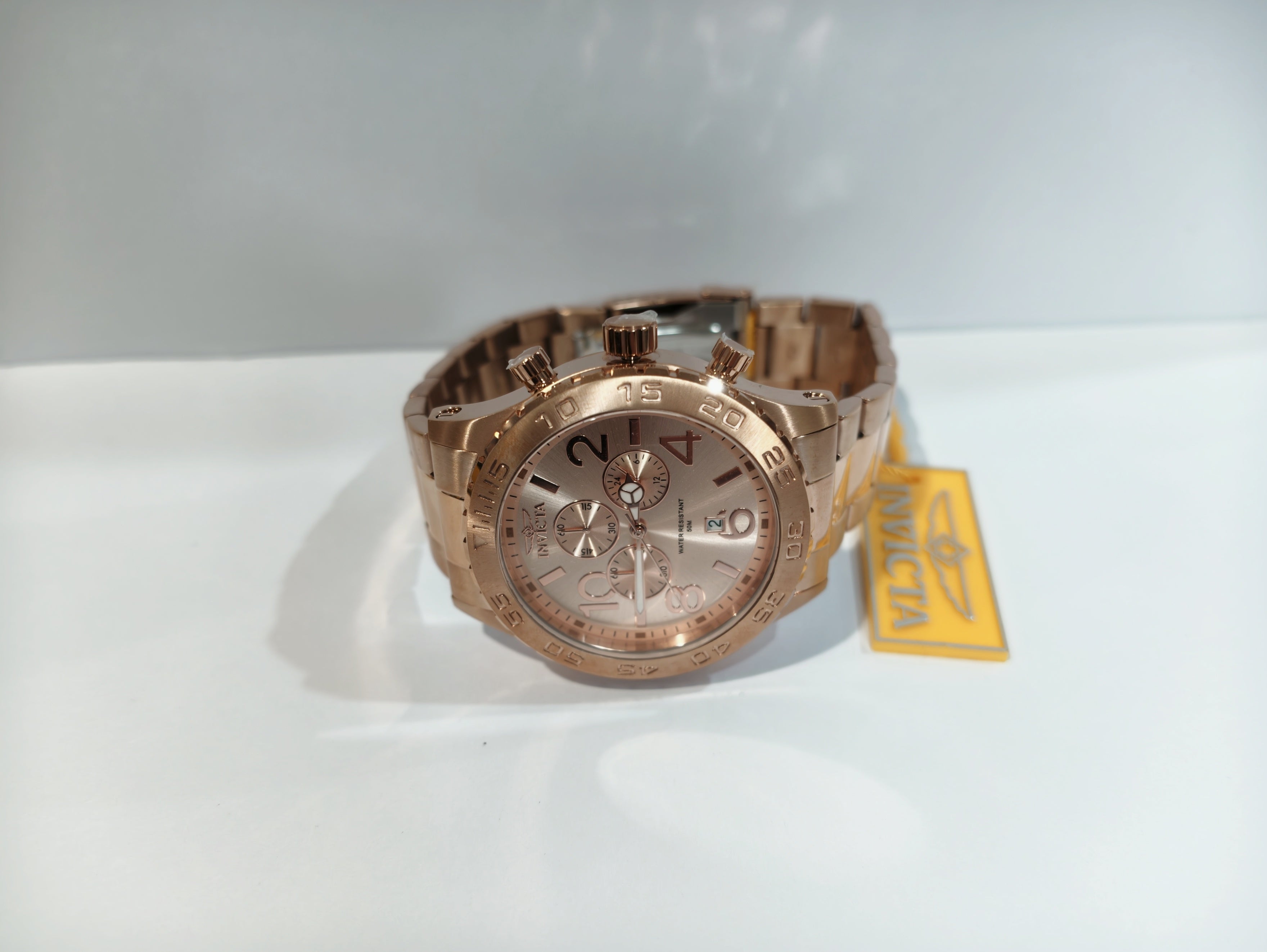 Invicta men's rose gold watch dial close-up showing chronograph subdials and date window
