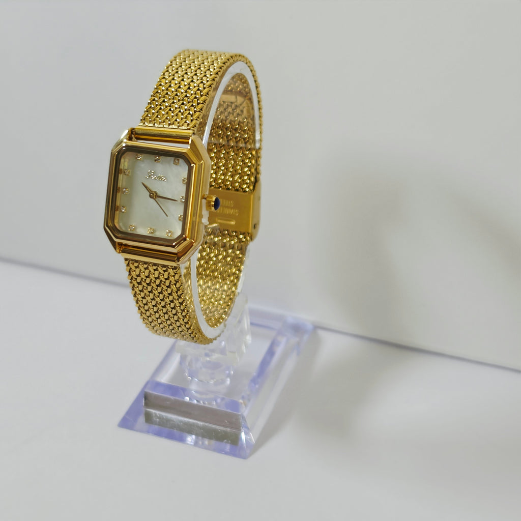 Womens gold mesh bracelet watch with square white dial and crystal markers on wrist
