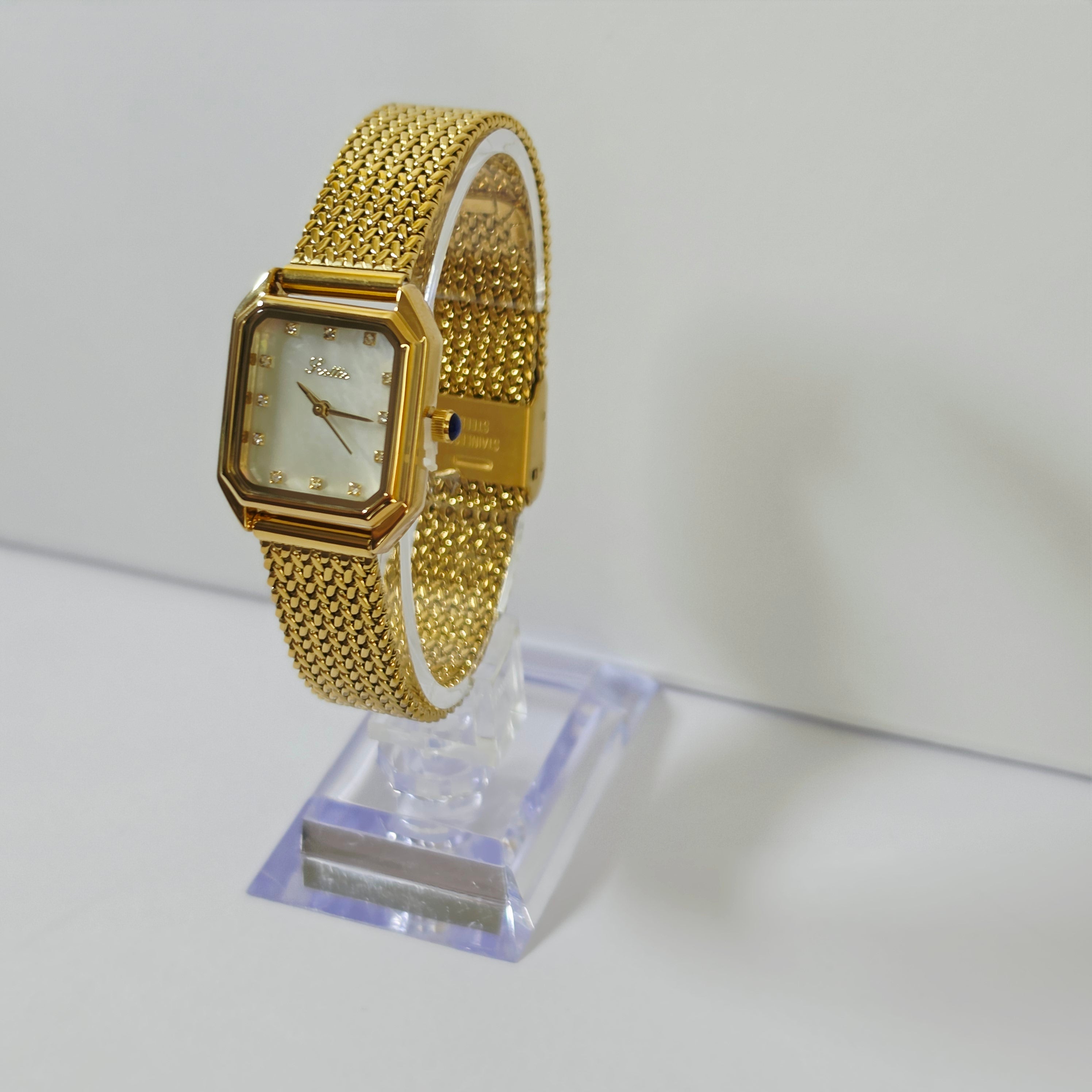Womens gold mesh bracelet watch with square white dial and crystal markers on wrist