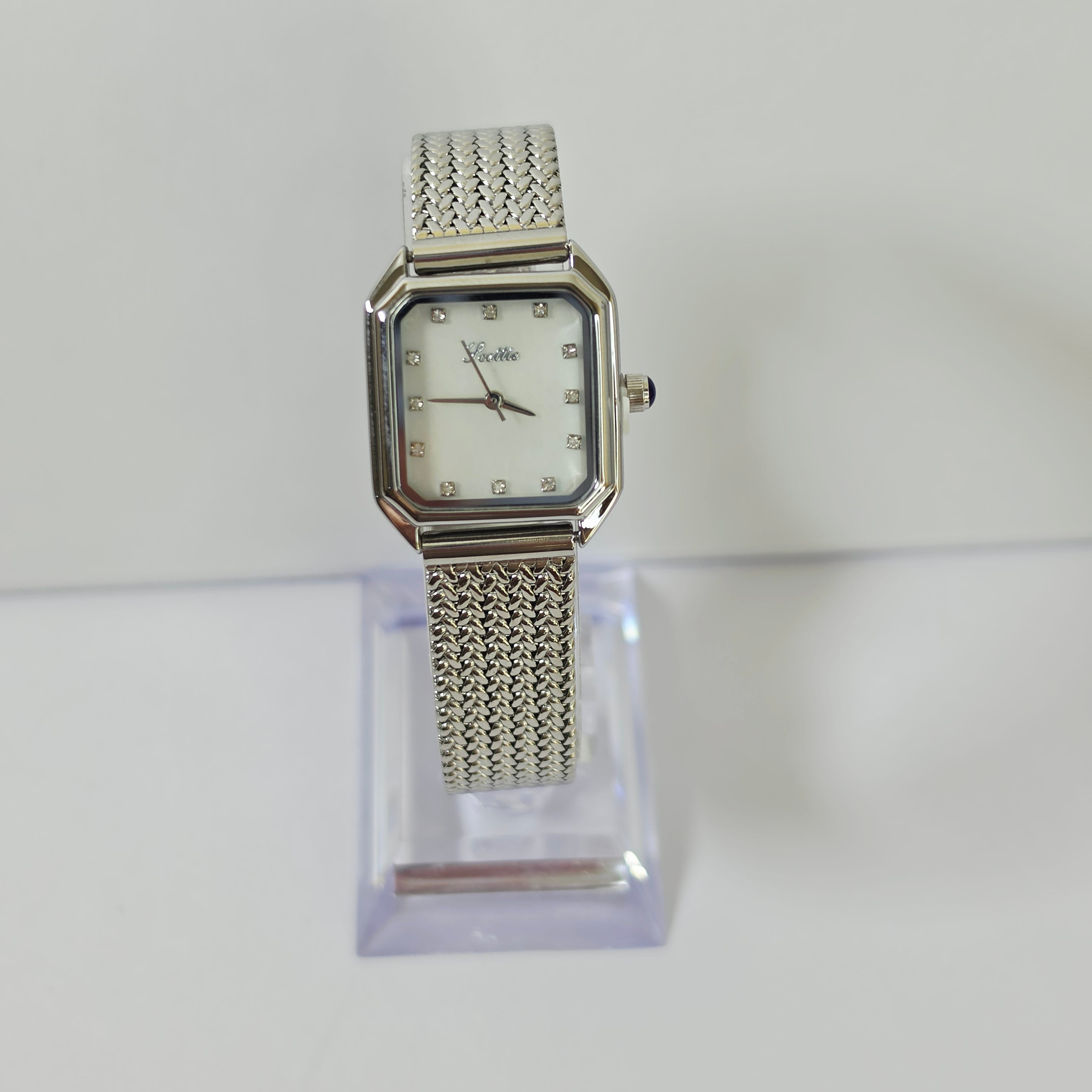 Womens silver mesh watch with square white dial and crystal markers on wrist angled view