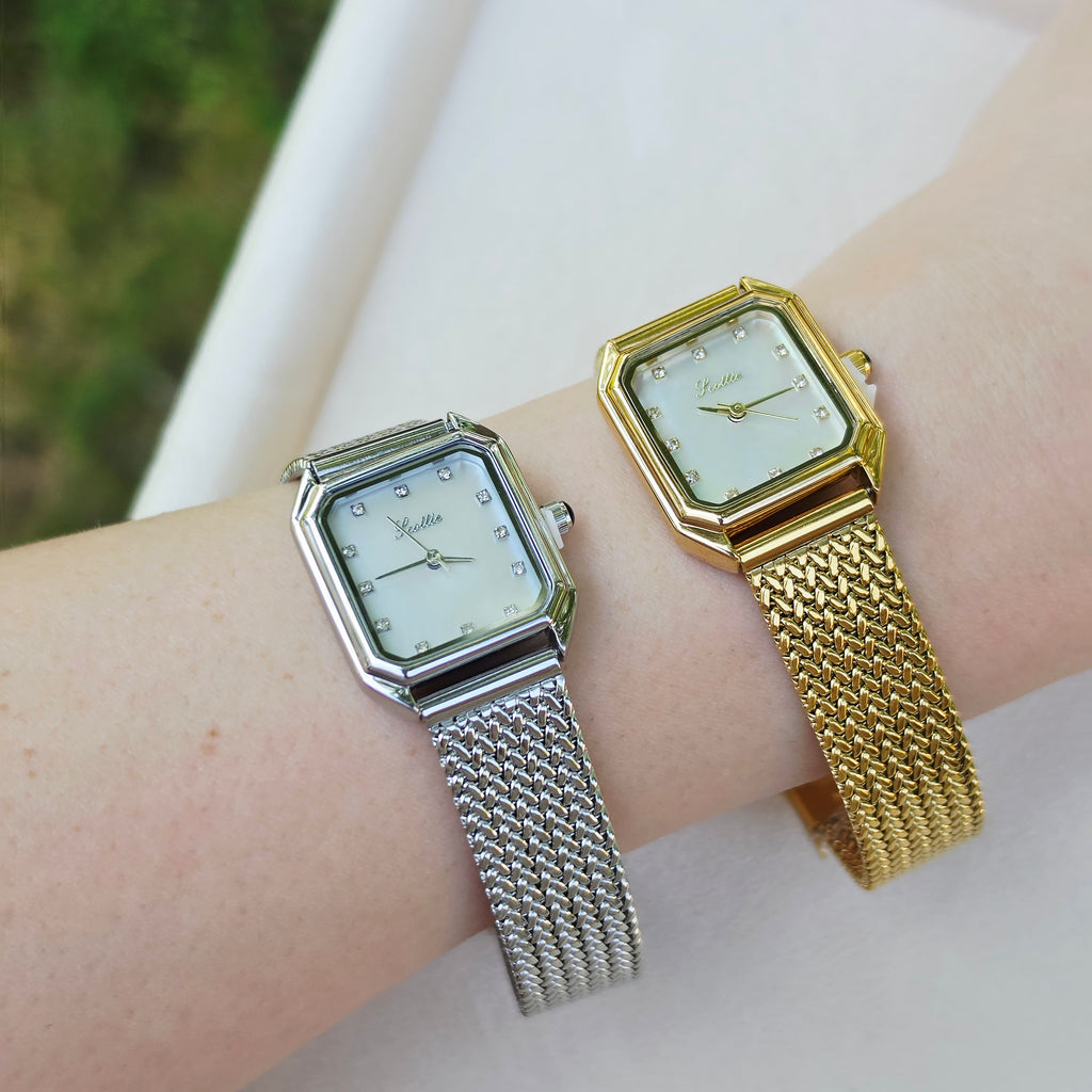 Two women's analog wristwatches with octagonal silver and gold-tone cases and mesh straps, shown on a person's wrist against a light neutral background.