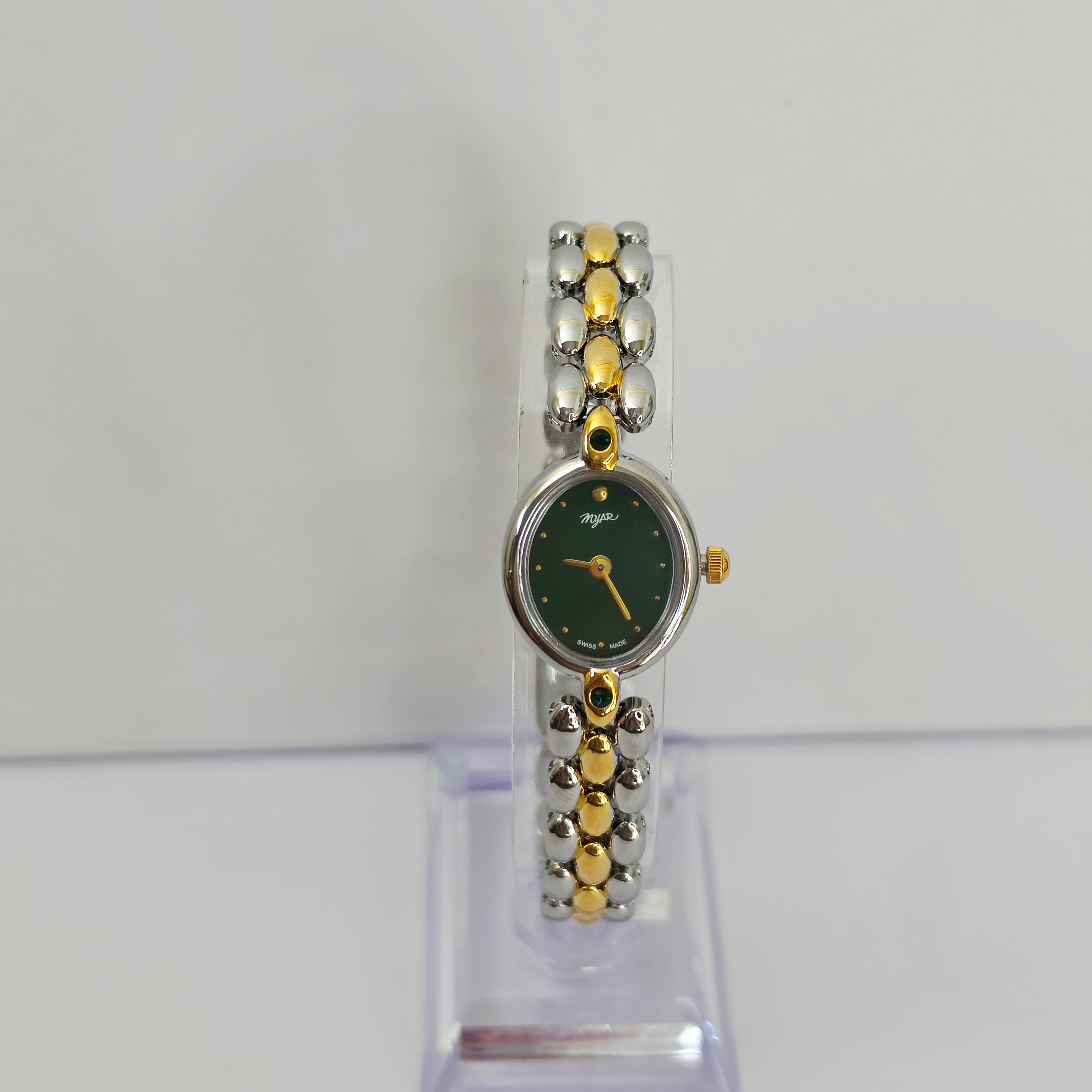 A women's two-tone watch with a dark green dial and a silver and gold beaded link bracelet, displayed on a clear stand against a light gray background.