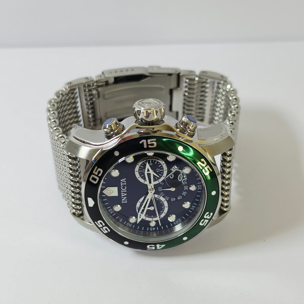 Invicta stainless steel mesh watch with a dark blue dial, green bezel, and silver case on a white background.