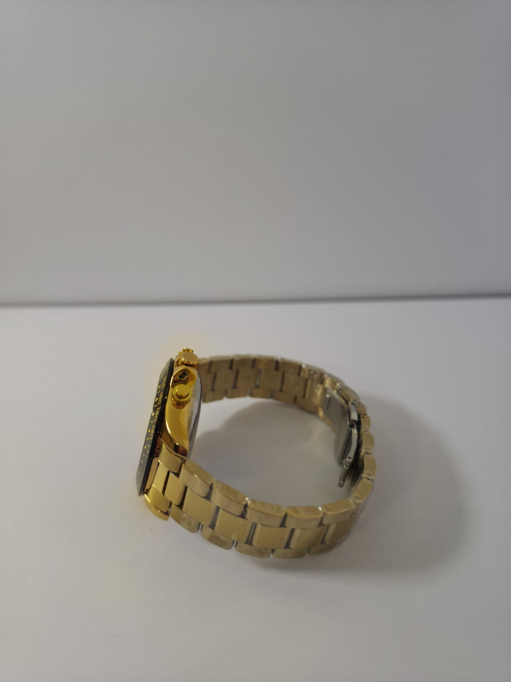 Side view of Veadons gold chronograph watch showing crown, pushers, and bracelet links

