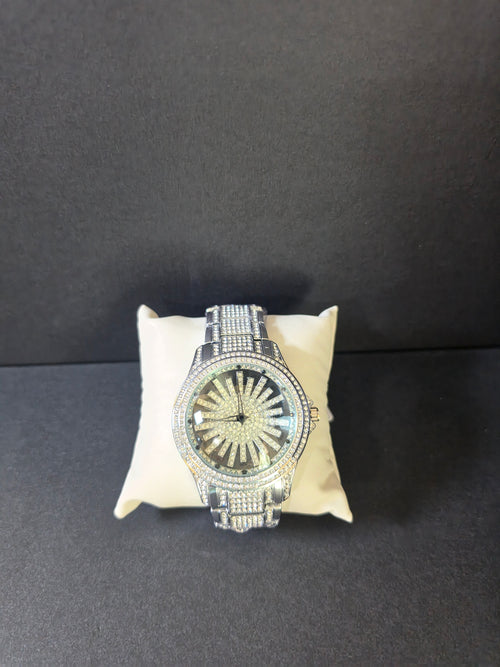 Front view of silver-tone crystal pavé watch with sunburst dial on cream pillow