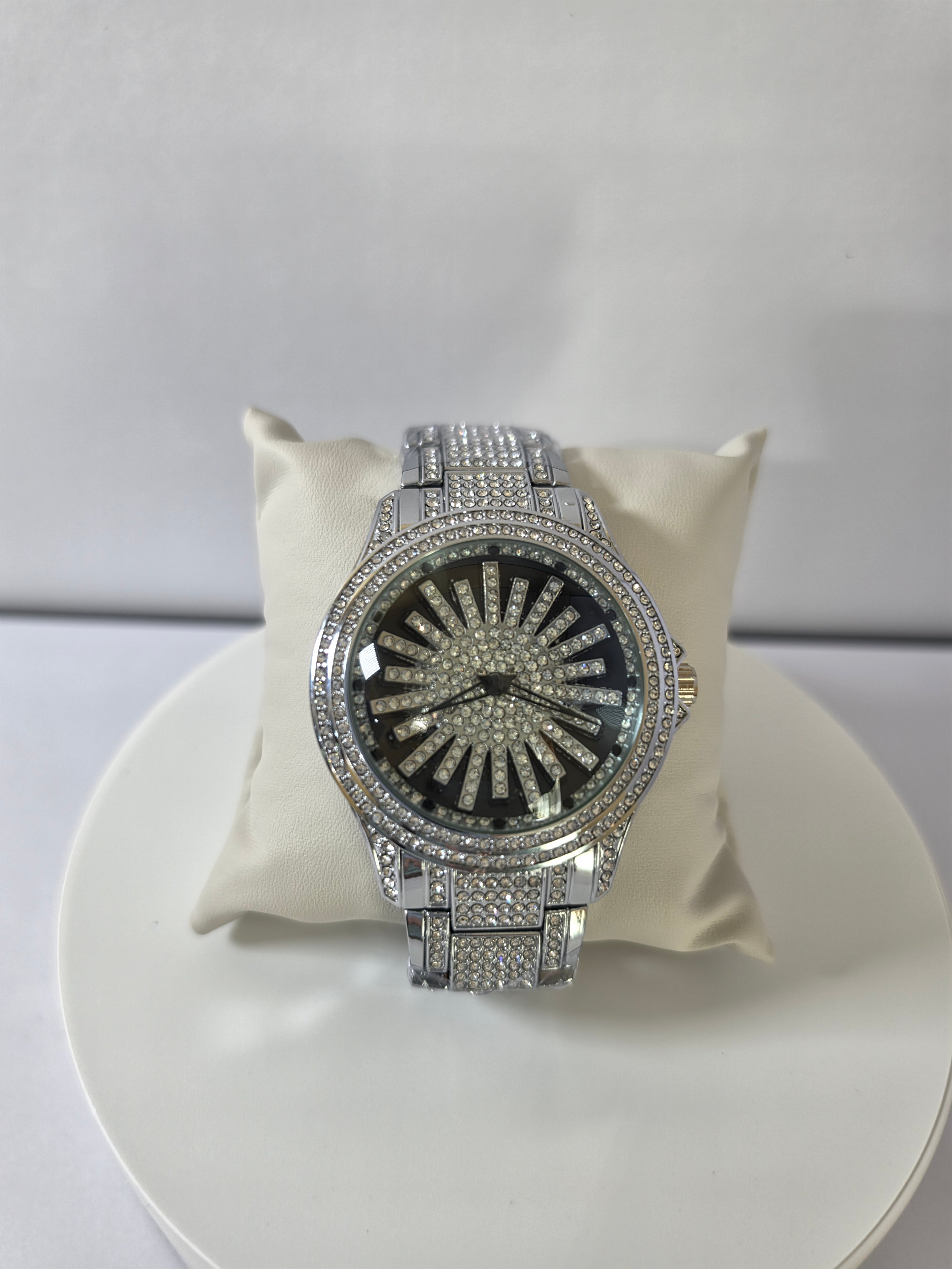 Silver-tone iced-out watch with crystal pavé dial on cream display pillow, top view